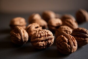 A close-up of brown walnuts on a dark surface, showcasing their textured shells and rich details.
