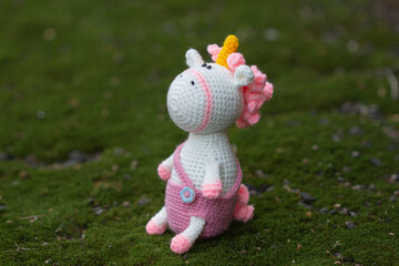 Knitted unicorn with a pink mane in a pink jumpsuit