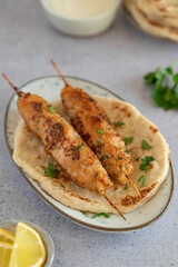 Chicken Kofta Kebab on wooden skewers with pita, garlic sauce Toum, parsley and lemon. Chicken skewers, shish kafta tavuk. Traditional Middle East food. Lebanese, Turkish cuisine. Food photography.