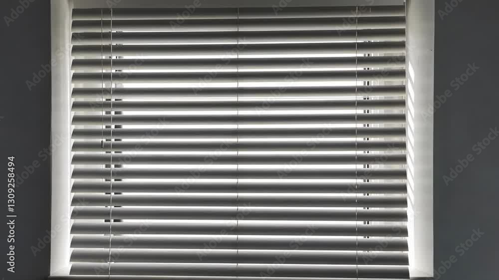 Poster light filtering through horizontal window blinds in a modern interior during the day