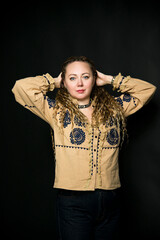 beautiful lady with long curly hair in beige ukrainian traditional  dress embroidery on black background