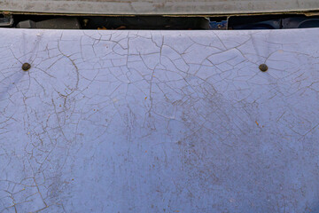 cracked paint on the hood of a car. peeling paint. putty on a car element.