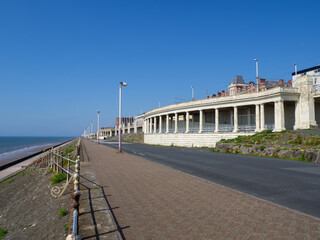 the long pedestrian promenade in North Blackpool in summer with the sea at high tide in summer...