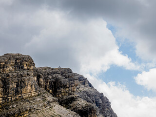 Formación rocosa alpina bajo cielo nublado y azul