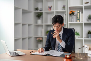 Young businessman reviewing important documents and contemplating strategy in a modern office.