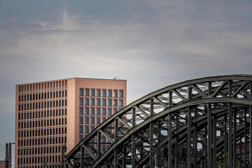 A prominent modern office tower stands behind a metal bridge in Germany, illustrating the country’s industrial heritage and contemporary business landscape. Structural steel meets urban development.