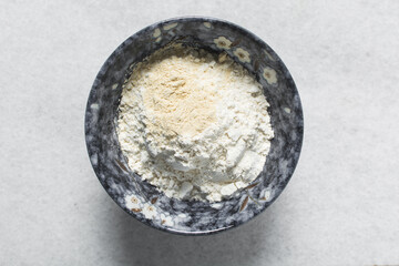 All purpose flour and vital wheat gluten in a ceramic bowl, process of making bread flour