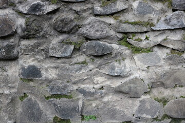 Close-up of rough stone wall with irregular shapes and natural textures. Perfect for backgrounds, architectural designs, and rustic-themed projects.