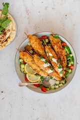Chicken Kofta Kebab on wooden skewers with pita, garlic sauce Toum, parsley, lemon, cucumber and tomato. Shish kafta tavuk. Traditional Middle East food. Lebanese, Turkish cuisine. Food photography.