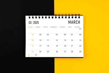 March 2025 desk calendar on black and yellow background, Flat lay.