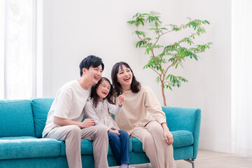 リビングでみんなでテレビを見るファミリー