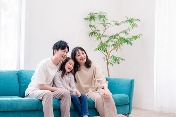 リビングでみんなでテレビを見るファミリー