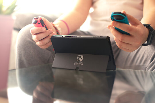 Girl playing with her Nintendo Switch console. Rear view with the logo centered.