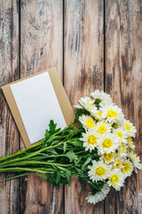 Vertical Chrysanthemums on wooden textured brown background. Festive holiday greeting card for Birthday.