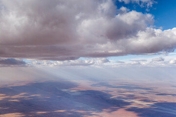 Fototapeta premium large thunderstorm clouds cast shadows over pans and red sand dunes in desert countryside, near Bagatelle ranch, Namibia