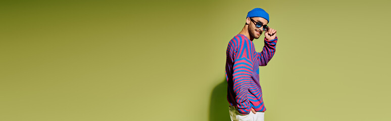 Handsome young man exudes confidence in stylish ensemble with vibrant sunglasses
