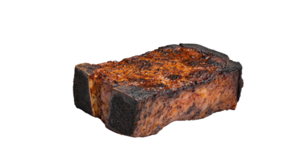 A piece of meat is burnt and has a lot of seasoning on it