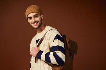 Handsome young man showcases winter fashion in stylish outfit with trendy beanie hat