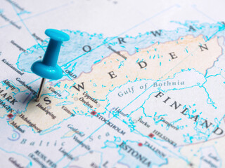 A macro a pin marking the location of Sweden on a world map.