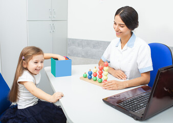 A child engages joyfully with colorful toys while an occupational therapist facilitates skills development through play at a therapy center