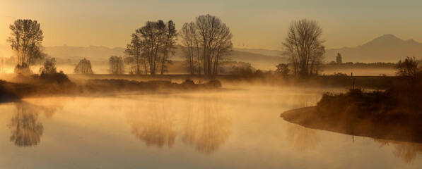 Foggy autumn morning at the tranquil river
