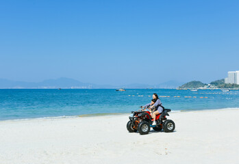 Obraz premium Asian kid and mom riding ATV at in Xunliao Bay, Huizhou city, Guangdong Province, China, during January