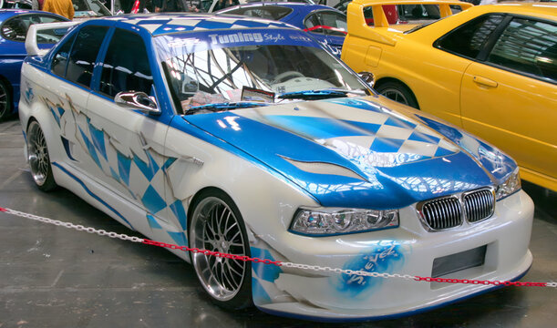 Rimini, Italy : 2019 03 29 Rimini Tuning free auto meeting BMW E36 with a custom blue and white paint job and aftermarket wheels, at an indoor event.