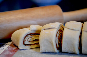 Close up of Cinnamon Roll freshly cut with rolling pin in background