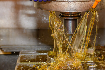 The CNC milling machine rough cutting the mold parts with liquid coolant method.