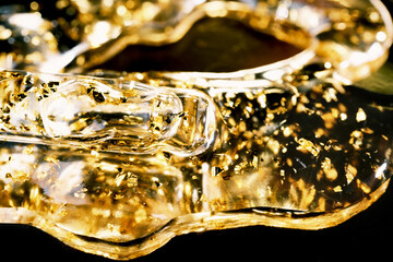 Pipette and skincare serum with gold flakes for luxurious treatments