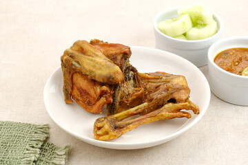 Ayam Goreng or Fried Chicken with sambal and cucumber, Indonesian food
