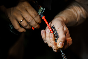 Expert Hands Performing Precision Craftsmanship in a Dimly Lit Workshop