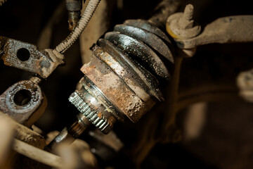 Close-up View of Dirty and Rusty Car CV Joint and Suspension Components Showing Wear and Damage