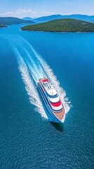 Fototapeta premium Luxury yacht speeding across a calm blue sea, surrounded by lush green islands under a bright sunny sky. Aerial view.
