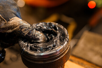 Close-Up of Worker Applying Grease Lubricant to Mechanical Part with Finger While Wearing a...