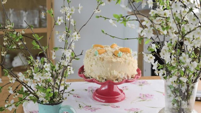 Spring cake decorated with pastel eggs and flowers, placed on a red stand. A delicate and festive scene with blooming branches, perfect for Easter, celebrations, and seasonal joy. High quality 4k 