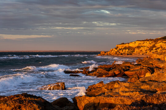 waves crashing on rocks in late afternoon light