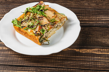 Delicious homemade savory pastry with fresh herbs on a rustic wooden table