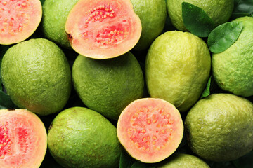 Fresh cut and whole guava fruits with water drops as background, top view