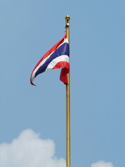 The siam flag flutters in the wind. The Thai national flag  has a sky and white clouds backdrop. Flag has 5 stripes, 3 colours: blue, red, white. Winds blew up. Thai flag waving on flagpole, 
