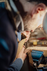 Obraz premium Luthier carefully working on violin scroll in workshop