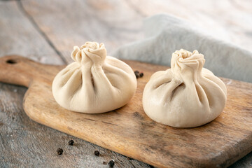 Chinese raw dumplings with pork and vegetables on a wooden cutting board