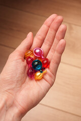 In a woman's hand, capsules of oil for hair beauty. Beauty is in their hands. Multi-colored capsules.