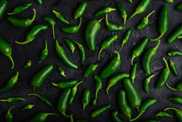 Background of Ripe Green Jalapeno Peppers on Dark Concrete Surface