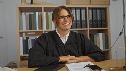 Woman smiling in office wearing judge robe brunette female sitting at desk indoors office workplace