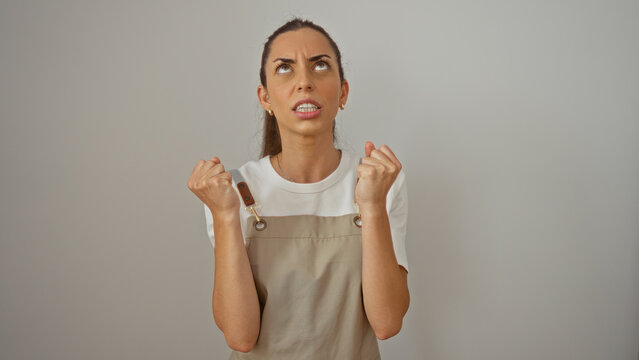 Frustrated woman feeling angry with clenched fists over isolated white wall background