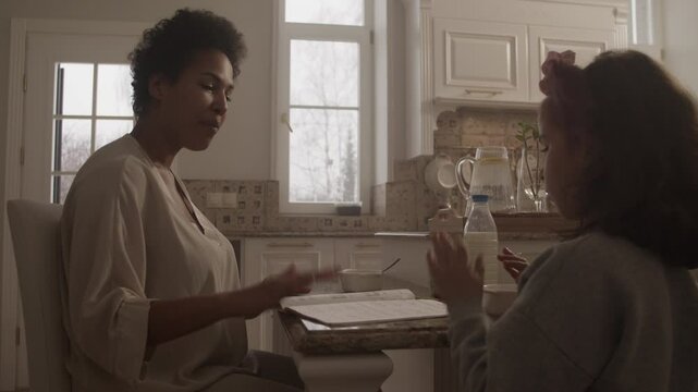 Black woman singing solfeggio music along with daughter at table