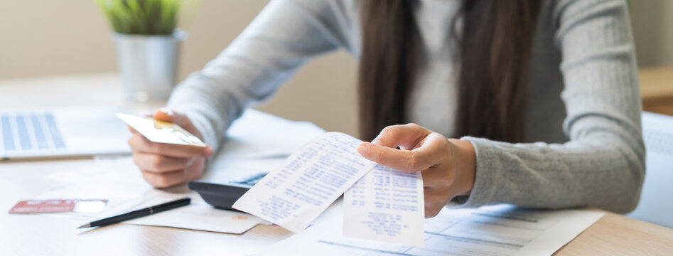 Business financial concept, stressed asian young business woman hand holding credit card for calculate accounting expense of bill, tax for payment on due deadline, trying to find money to pay debt.