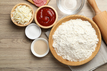 Making calzone pizza. Different ingredients on wooden table, flat lay