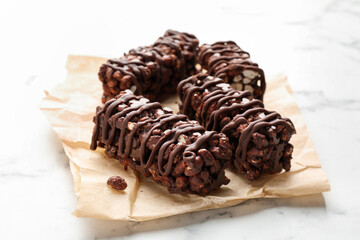 Delicious chocolate puffed rice bars on white marble table, closeup